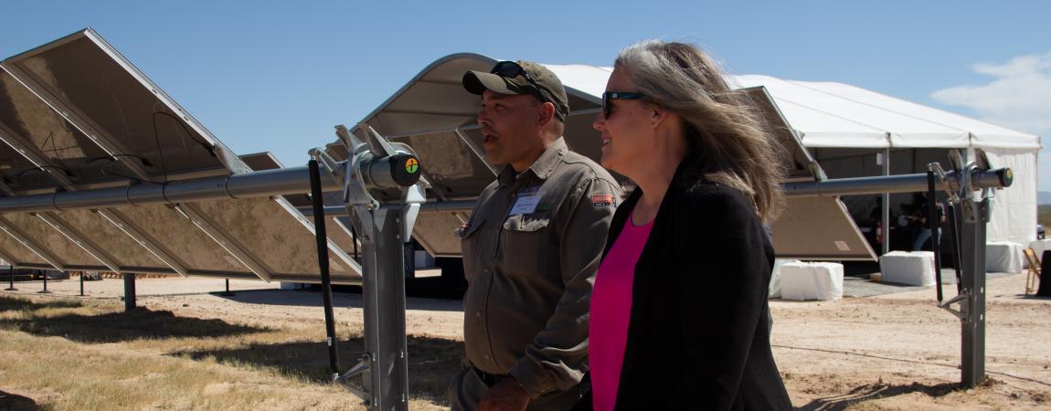 Governor Hobbs walking with a man through a solar panel field.
