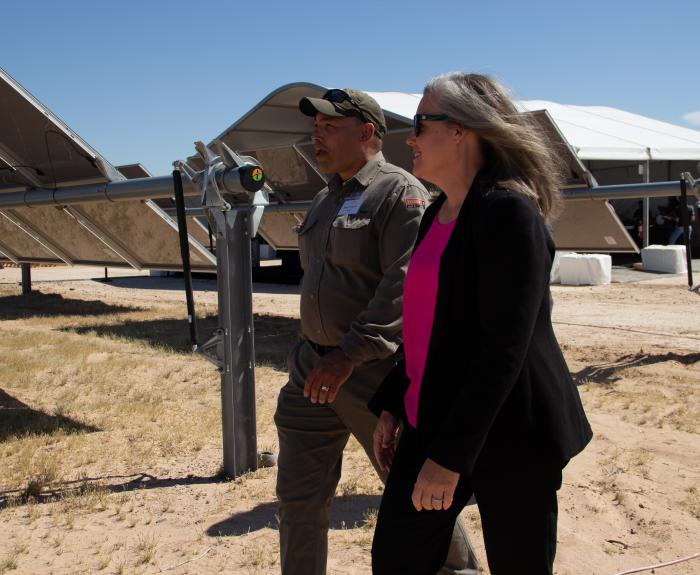 Governor Hobbs walking with a man through a solar panel field.