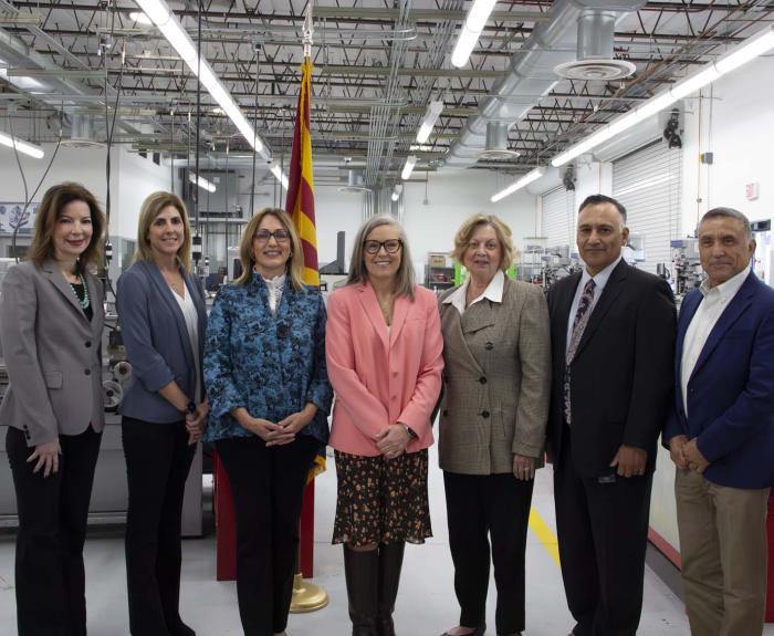 Governor Hobbs surrounded by people in a fabrication facility
